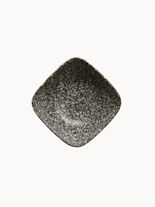 Widok z góry na ceramiczną miskę, pokrytą nakrapianą czarno-białą strukturą z poziomymi prążkami, na jednolitym białym tle.